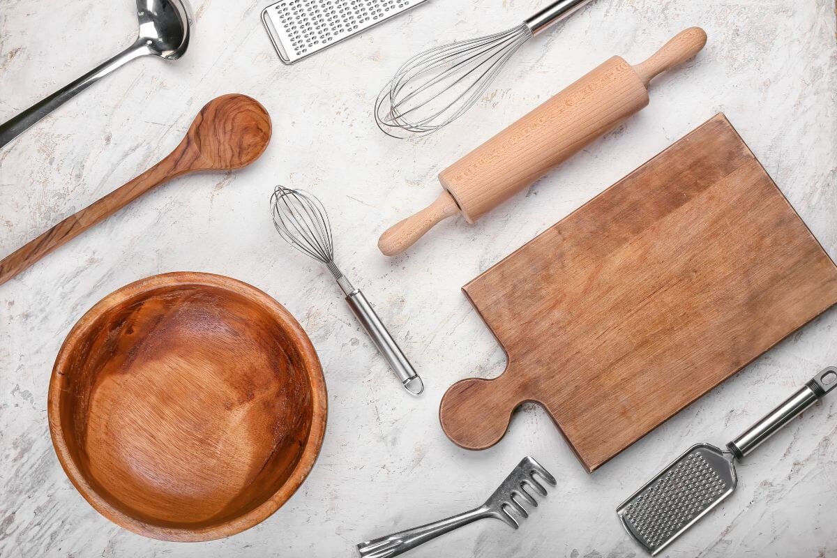 Kitchen tools for Italian cooking including a knife, cutting board, grater, and pasta bowl